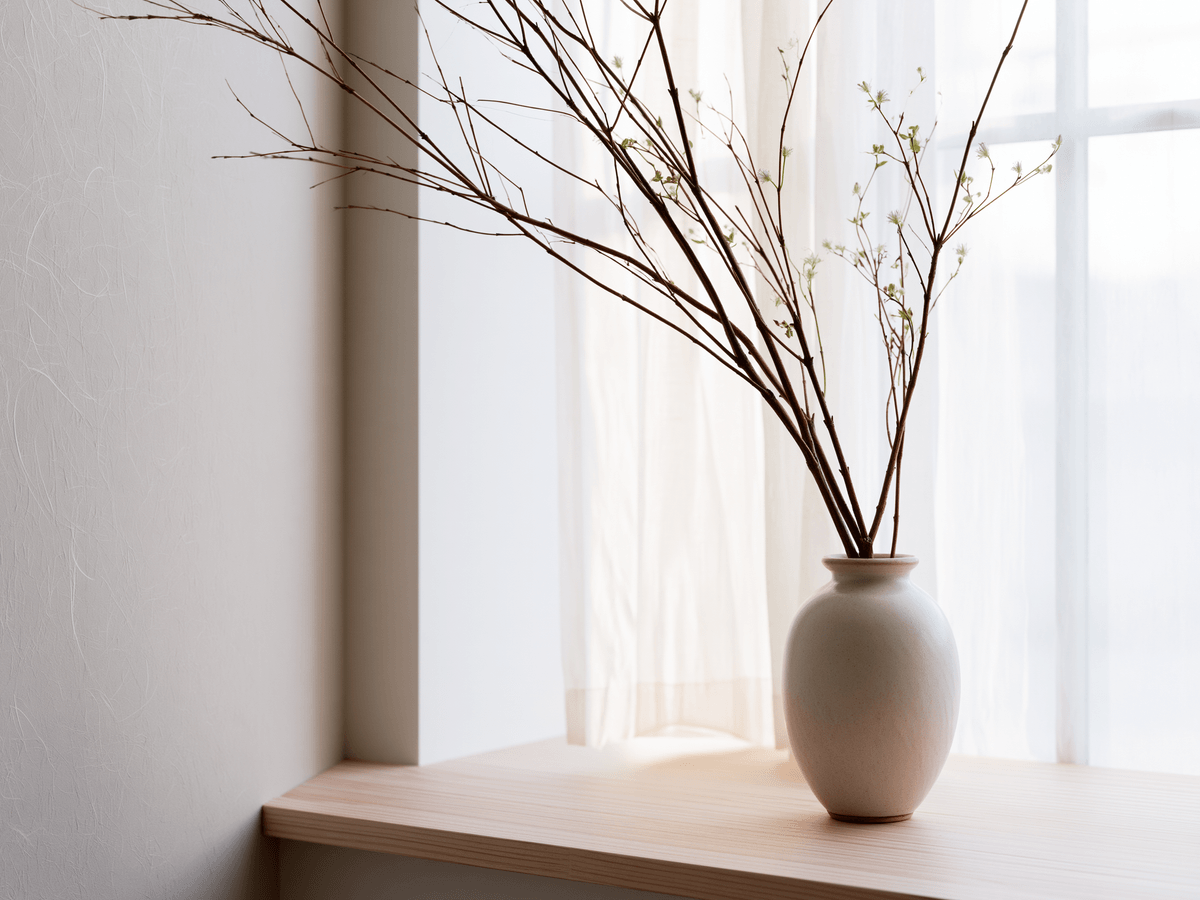 Natural materials — branches and ceramic vase by window